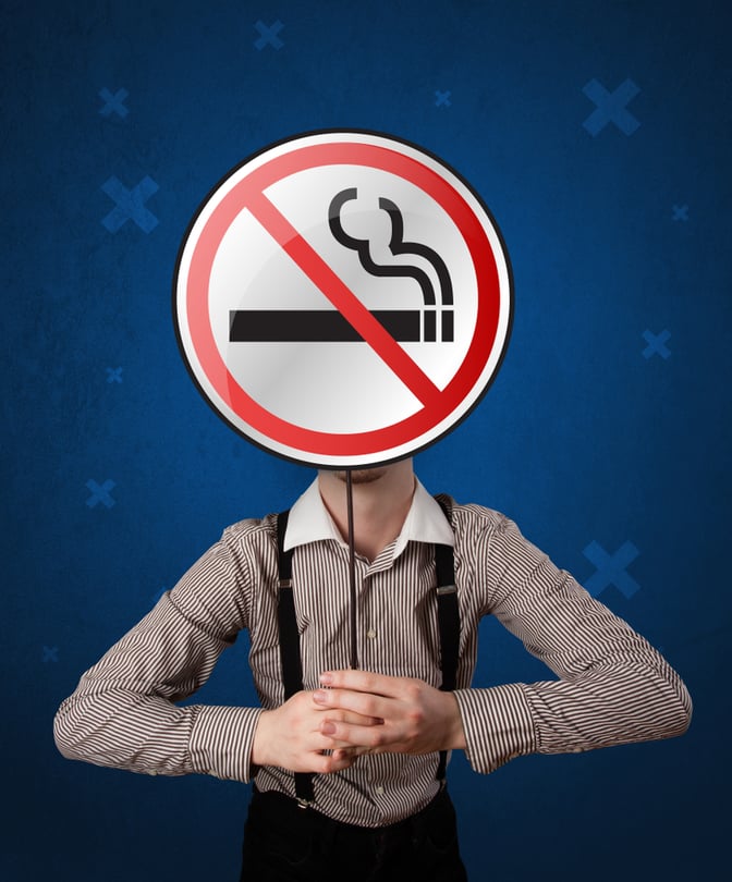 Casual businessman holding round sign with no smoking graphic